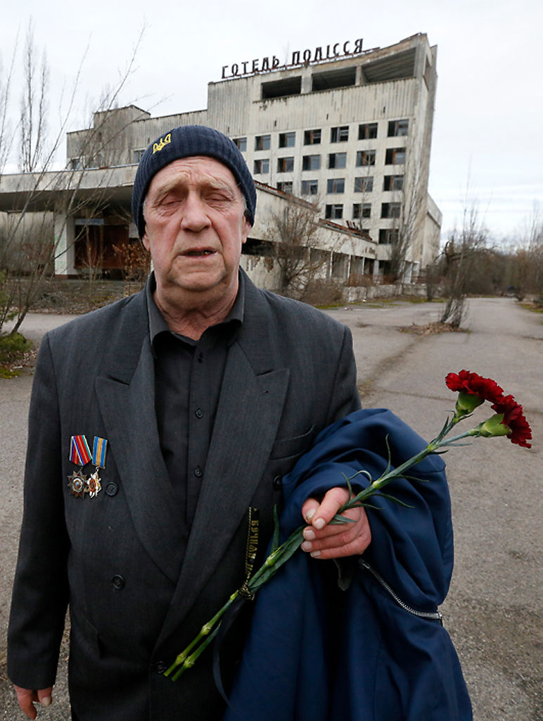 Former resident of Pripyat, Olexander Zabelchenko holds flowers